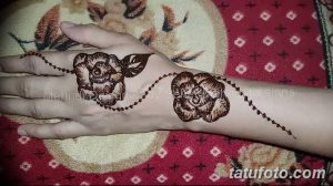 Фото тату хной с изображением двух роз на ладони. Детализированный рисунок с использованием коричневых оттенков.