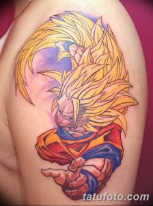 Фото тату на плече с изображением Супер Сайяна Гоку из аниме Dragon Ball Z. Рисунок татуировки выполнен в ярких цветах с использованием желтого, красного и синего оттенков.
