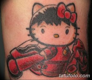 Фото тату на руці з зображенням Hello Kitty, виконане в яскравих червоних та чорних кольорах з деталізованим зображенням персонажа.