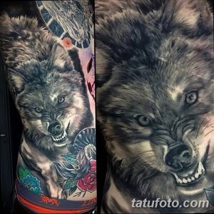 Фото тату волка на боку, в окружении роз. Детализированный рисунок с реалистичной проработкой шерсти и цветов.