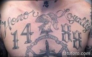 Фото большой татуировки на спине с изображением цифры 88, рун, текста 'Honor' и 'Loyalty', выполненной в черно-серых тонах.