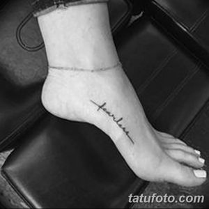 Черно-белое фото татуировки на стопе с надписью "fearless", выполненной каллиграфическим шрифтом.