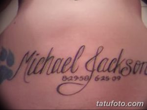 Фото тату на боку с именем 'Michael Jackson' и датами рождения и смерти. Черно-серый рисунок татуировки, выполненный каллиграфическим шрифтом.