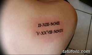 Фото тату: черные римские цифры 'II-XIII-MMIII', 'V-XXVII-MMIX' на плече. Несколько дат, выполненных в минималистичном стиле.