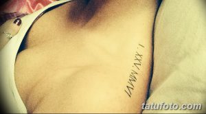 Фото тату: черные римские цифры 'I.XXV.MMVI' на боку женщины. Изящный и минималистичный рисунок татуировки.