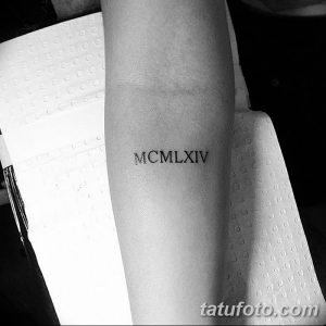 Фото тату: черные римские цифры 'MCMLXIV' на запястье. Простой и элегантный рисунок татуировки, выполненный четкими линиями.
