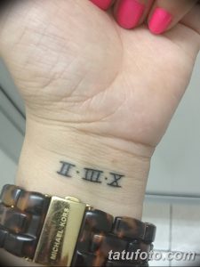 Фото тату: черные римские цифры 'II-III-X' на запястье. Простой и элегантный рисунок татуировки, выполненный четкими линиями.