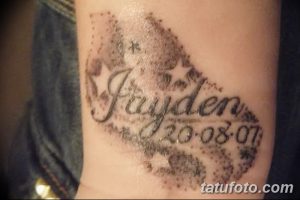 Фото тату с именем 'Jayden' и датой '20-08-07', выполненное в черно-серых тонах на предплечье. Эскиз татуировки с использованием звездных элементов.