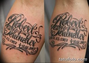 Фото тату с именем 'Robert Schneider' и датами жизни на руке. Черно-серая татуировка, выполненная в декоративном стиле.
