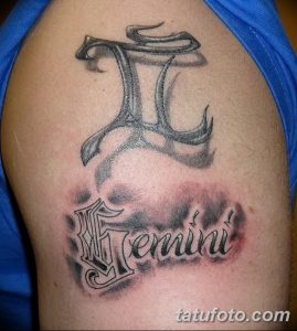 Фото тату знак зодиака Близнецы в серо-черных тонах с надписью Gemini на плече. Детализированный рисунок символа и красивый шрифт.