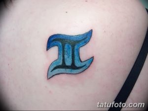 Небольшая цветная татуировка с изображением знака зодиака Близнецы в синих тонах. Динамичный дизайн и четкие контуры.