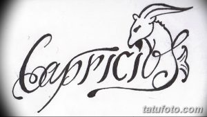 Фотография татуировки с надписью "Capricorn" и изображением козла. Стильный дизайн, выполненный черными чернилами.