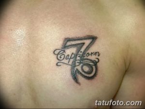 Фото тату: Татуировка Козерога на груди с надписью "Capricorn". Черно-серый рисунок с символикой зодиака.