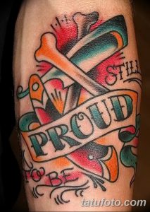 Фото яркой татуировки опасной бритвы с надписью 'Still Proud' на руке. Цветной рисунок татуировки в стиле олдскул.