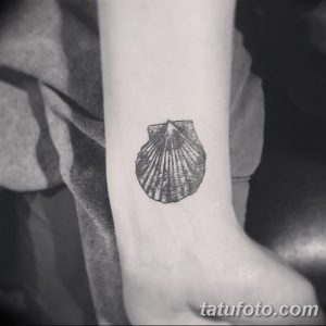 Фото простой татуировки раковины в технике blackwork. Черно-белый рисунок с использованием плотных штрихов.