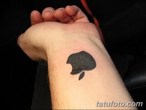 Фото тату логотипа Apple на запястье. Черный силуэт надкушенного яблока, простой и лаконичный рисунок татуировки.