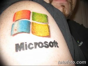 Фото тату логотипа Microsoft на плече. Четыре разноцветных квадрата, символизирующие операционную систему Windows. Яркий и узнаваемый рисунок.