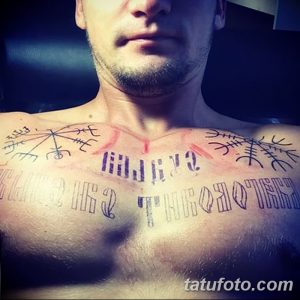 Фото тату: цветная татуировка на груди, включающая в себя руны, надпись и геометрические элементы. Стиль – скандинавский минимализм с яркими акцентами.