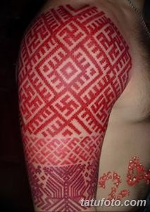 Фото тату с ярким славянским орнаментом на плече. Красный рисунок татуировки с использованием геометрических мотивов, выполненный в этническом стиле.