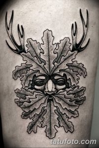 Фото тату с изображением лица Лешего, выполненного в стиле Blackwork. Черно-белый рисунок татуировки с детальной проработкой растительных элементов и рогов.