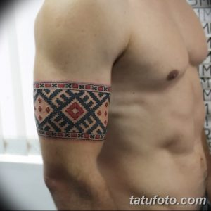 Фото тату славянского браслета на предплечье. Черно-красный рисунок татуировки с геометрическим орнаментом.