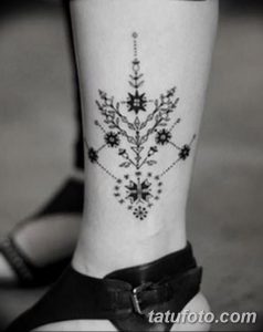 Фото тату: Черно-белое тату на лодыжке, выполненное в стиле лайнуорк. Изящные линии образуют абстрактный узор, напоминающий кружево или филигрань.