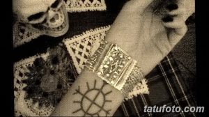 Фото минималистичной татуировки на запястье с изображением славянского символа. Черно-белый рисунок татуировки в графическом стиле.