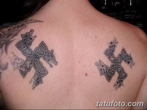 Фото парных татуировок на лопатках с изображением голов волков, выполненных в кельтском стиле. Черно-серые тона, детализированная проработка.