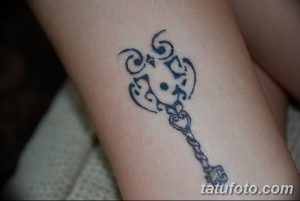 Фото татуировки на запястье: стилизованное изображение ключа в технике черной графики. Простой и элегантный дизайн.