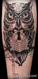 Фото тату совы с ключом в стиле blackwork на предплечье. Детализированный рисунок с использованием черных чернил и геометрических узоров.