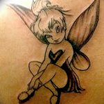 Фото тату феи Tinkerbell в полете, выполненное в черно-белой гамме на руке, с детально проработанными крыльями.