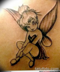 Фото тату феи Tinkerbell в полете, выполненное в черно-белой гамме на руке, с детально проработанными крыльями.