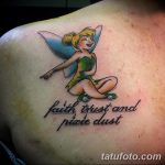 Фото тату феи Tinkerbell с надписью "Faith, Trust and Pixie Dust" на плече, выполненное в ярких мультяшных цветах.