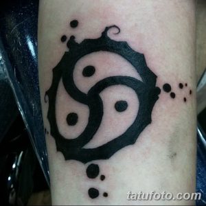 Фото тату кельтского трилистника, выполненного в стиле blackwork на предплечье. Рисунок состоит из черных заполненных областей и тонких линий, создавая графичный и эффектный образ.
