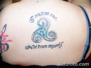 Фото тату кельтского узла на спине с надписью "I trust no one, not even myself". Сине-серый рисунок татуировки.