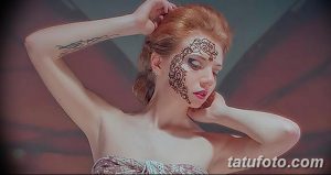 Фото тату мехенди на щеке девушки, с утонченным узором, выполненным хной черного цвета. Подчеркивает красоту и индивидуальность.