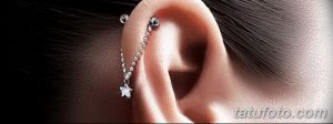 Фото пирсинга уха с серебряной цепочкой, проходящей через хрящ, и звездочкой на конце. Стильный и необычный дизайн для тех, кто любит оригинальность.