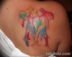 Фотография акварельной татуировки двух девушек, танцующих вместе. Фото демонстрирует пример татуировки в акварельном стиле.