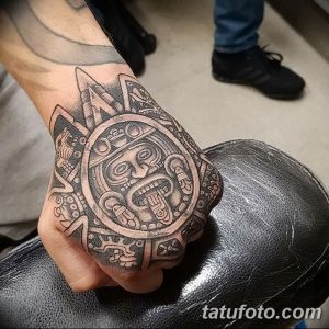 Фото тату: татуировка календаря майя на руке, выполненная в стиле blackwork с использованием четких линий и геометрических узоров.