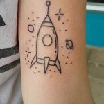 Фото тату с изображением простой ракеты, выполненной в стиле doodle, с использованием тонких черных линий. Минималистичный эскиз тату для любителей космоса.