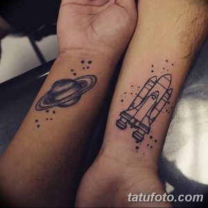 Фотография парных татуировок на запястьях с изображением ракеты и планеты. Черно-белые татуировки в минималистичном стиле.