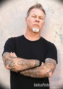 Фото тату Джеймса Хетфилда, вокалиста Metallica, с обширными татуировками на предплечьях в стиле олд скул и традиционной татуировки.