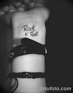 Фото тату с надписью 'Rock n' Roll' на женском теле. Черно-белый рисунок в каллиграфическом стиле.