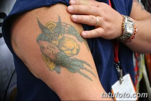 Фото старой татуировки Росомахи на плече. Выцветшие цвета, нечеткие контуры, потертый вид.