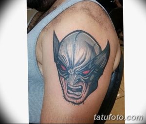 Фото классической татуировки Росомахи (Wolverine) на плече, выполненной в синих, серых и черных тонах. Изображение головы персонажа.