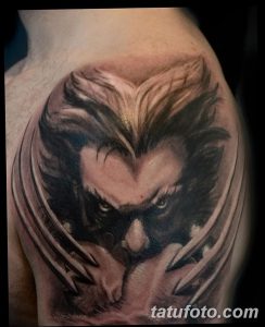 Фото реалистичной татуировки Росомахи (Wolverine) на плече, выполненной в черно-серых тонах. Детализированное изображение лица и когтей.