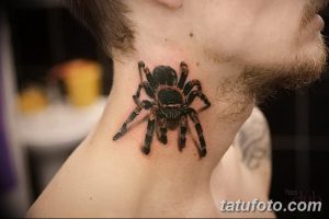 Фото тату реалистичного черного паука на шее. Детализированный рисунок с красными акцентами, выполненный опытным мастером тату.
