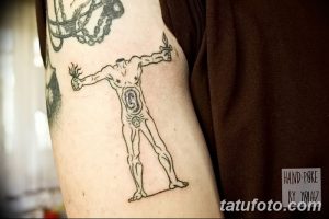 Фото хэнд-поке татуировки на руке: абстрактная фигура человека с сердцем вместо живота. Черно-белый рисунок, выполненный в минималистичном стиле.