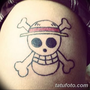 Фото татуировки на плече: изображение Чоппера, персонажа аниме One Piece, в мультяшном стиле. Черно-белый рисунок с элементами красного цвета.