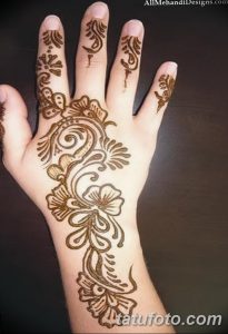 Фото тату хной на руке: изящный цветочный узор, украшающий ладонь и пальцы, выполненный в коричневых тонах. Идеально для вдохновения.